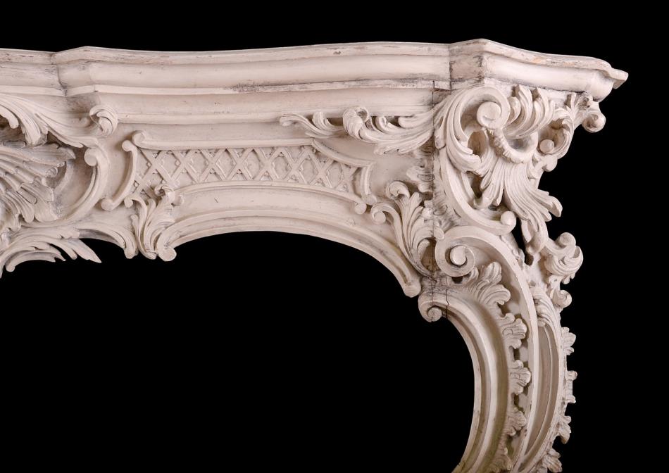 A well carved pine Rococo fireplace in the manner of Thomas Chippendale