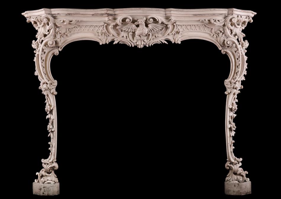A well carved pine Rococo fireplace in the manner of Thomas Chippendale