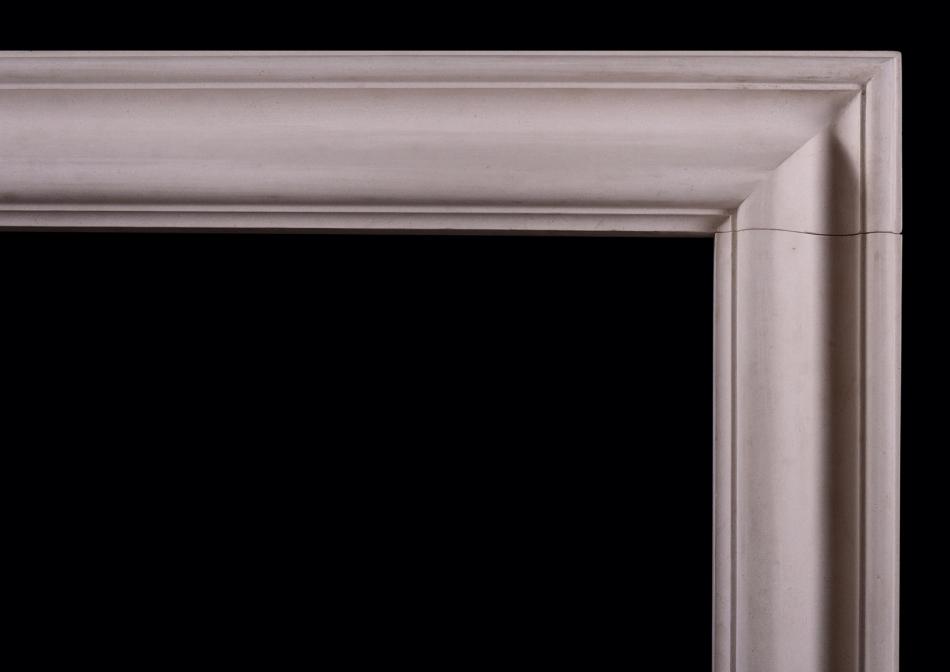 A bolection fireplace in a light coloured limestone