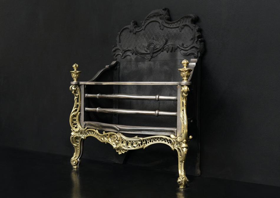 An attractive Rococo brass and steel fire grate