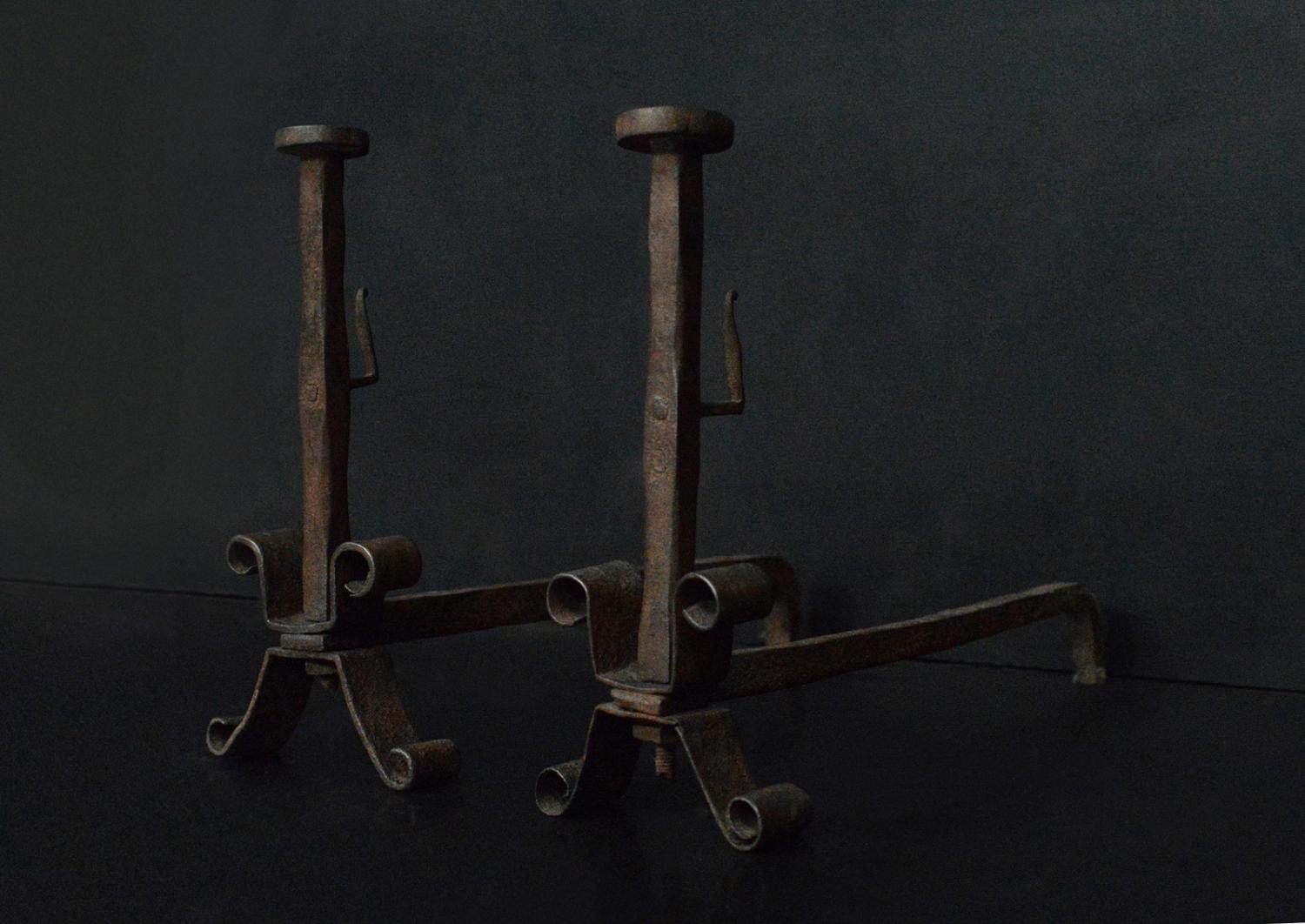 A pair of wrought iron firedogs