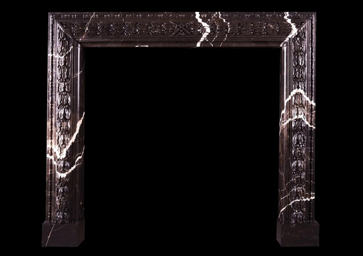 A carved bolection fireplace Brown Marquina marble