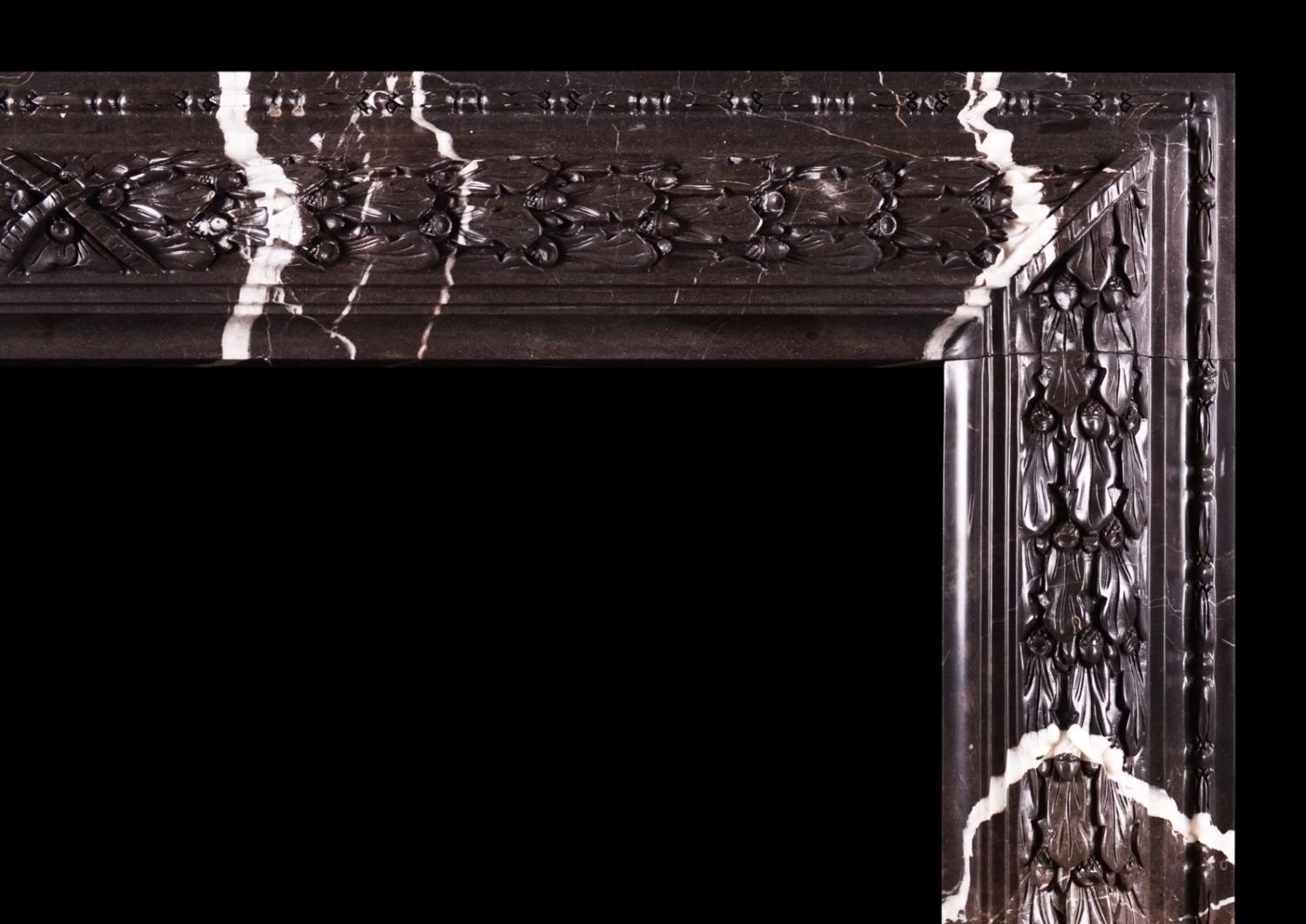 A carved bolection fireplace Brown Marquina marble