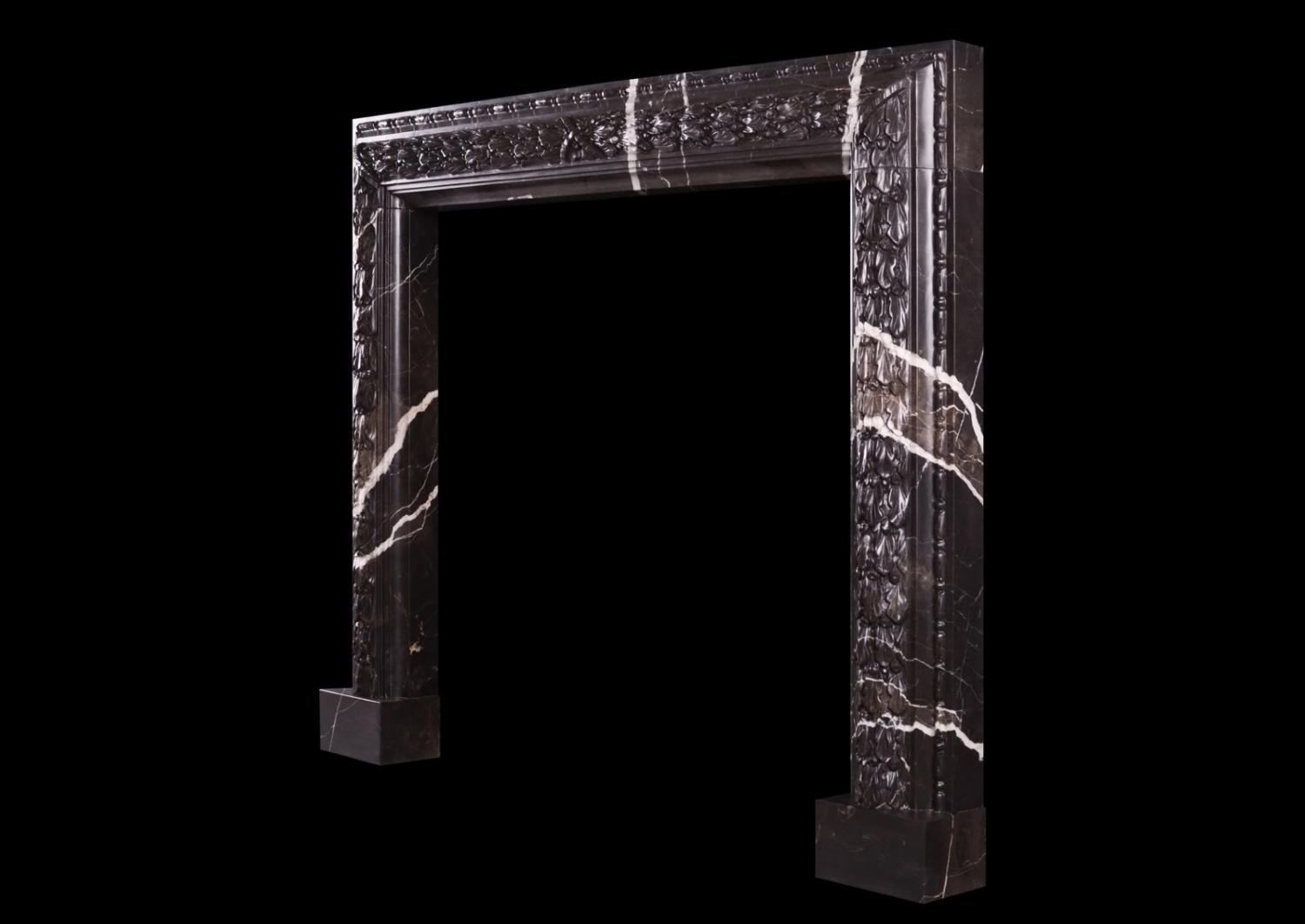 A carved bolection fireplace Brown Marquina marble