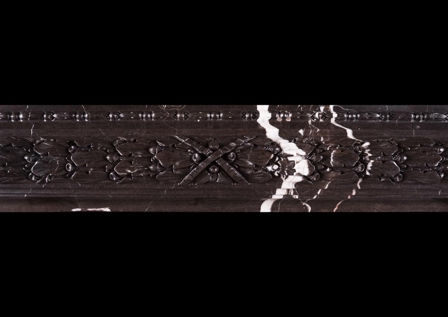 A carved bolection fireplace Brown Marquina marble