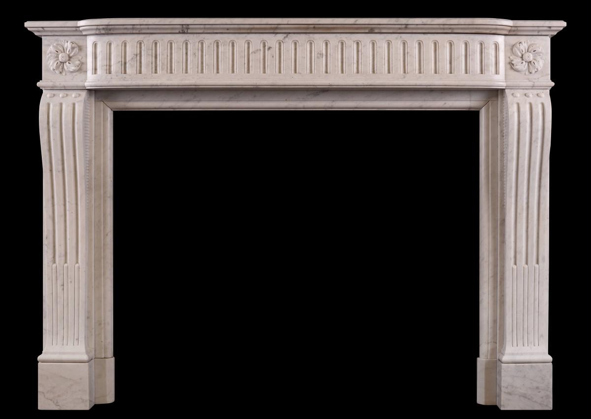 A Louis XVI style fireplace in a light Carrara marble